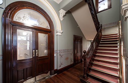 Image of hallway and staircase, with decorated glass panel doors