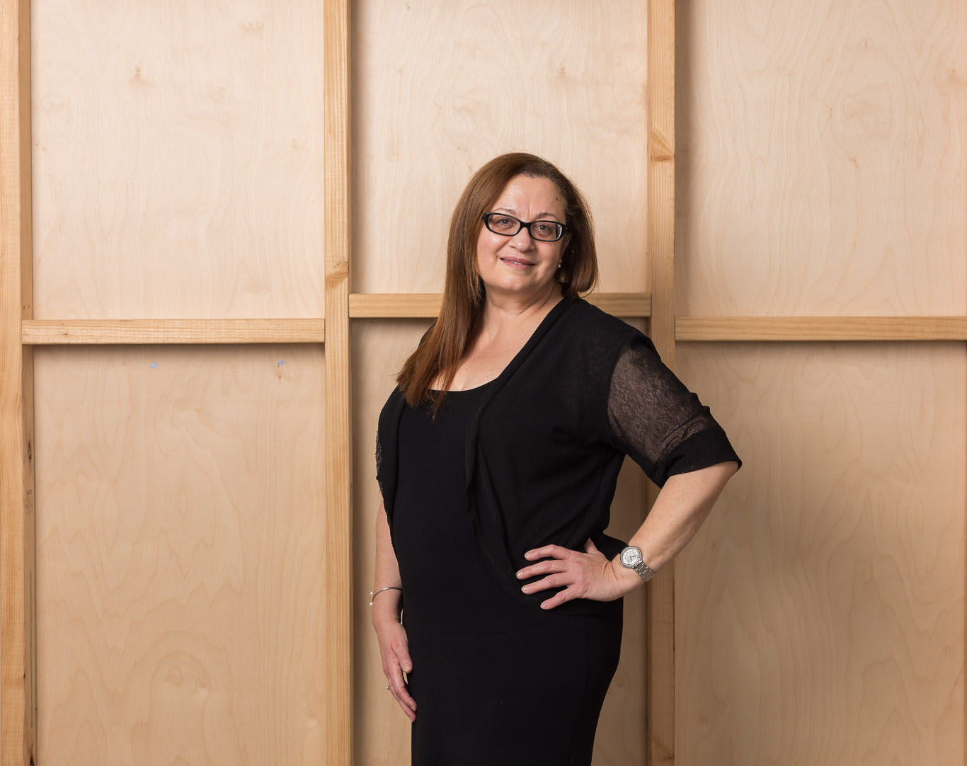 Person standing against a wooden backdrop