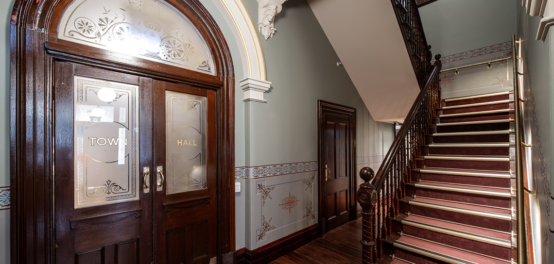 Image of hallway and staircase, with decorated glass panel doors