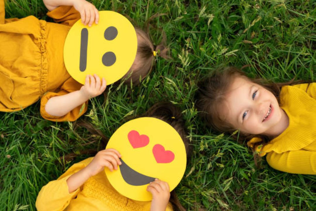 children laying on grass with smiley faces