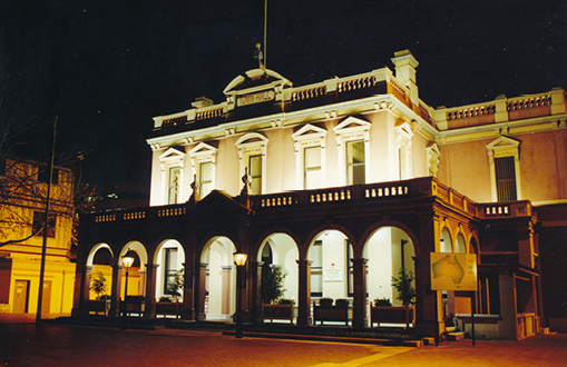 Image of town hall at night, with the exterior lit up