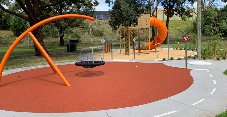 Giant swing, slide with climbing equipment surrounded by a bike/scooter track