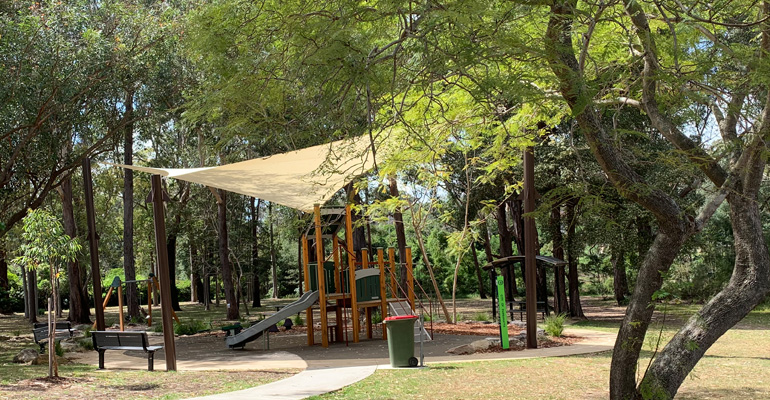 Playspace with shade cloth and surrounded trees