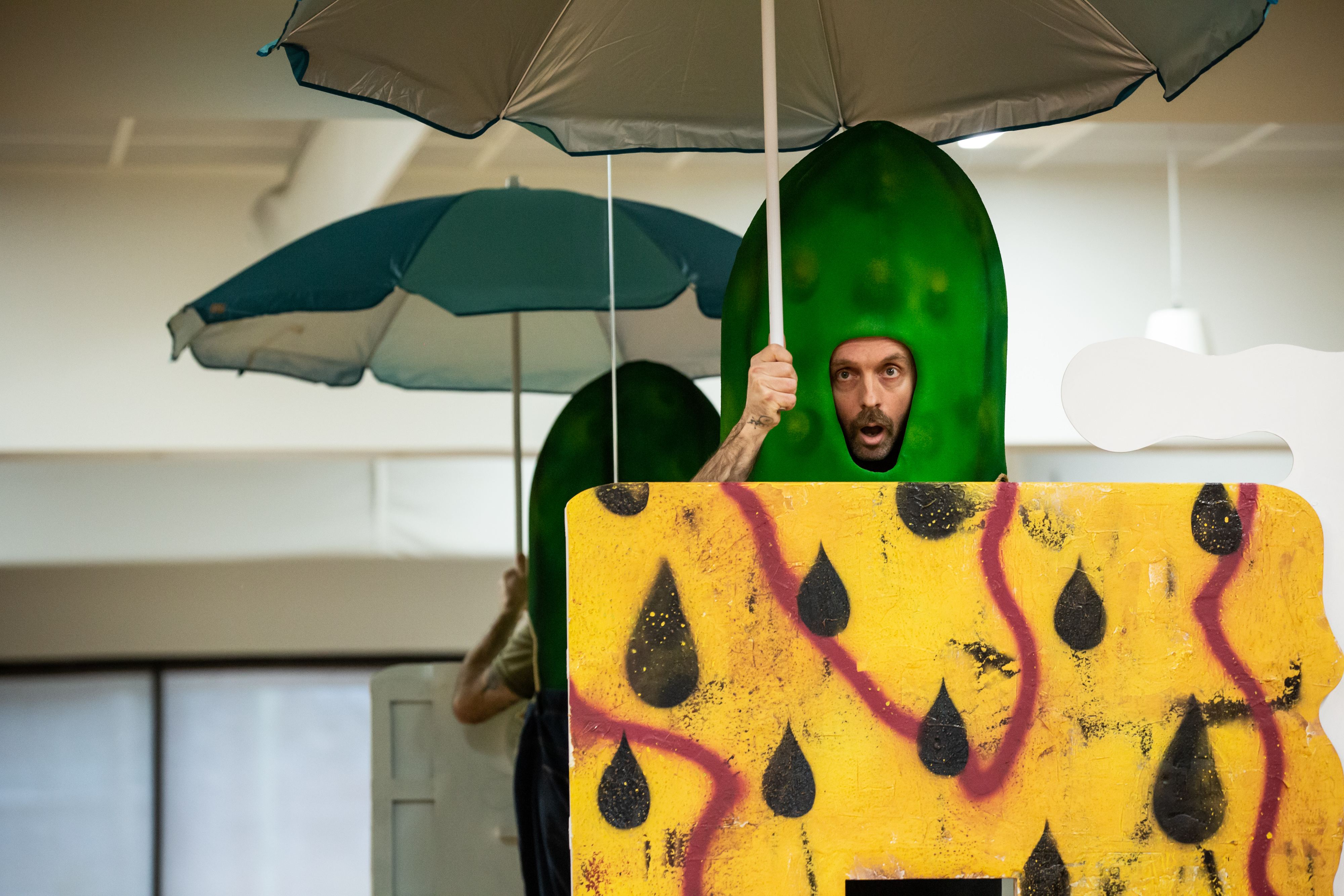 A man in a colourful costume under an umbrella
