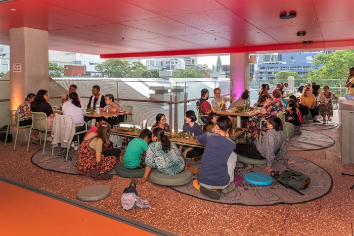 Group of people sitting at tables and on the ground on Western Terrace