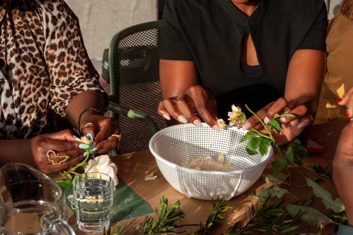 Two sets of hands picking flower petals