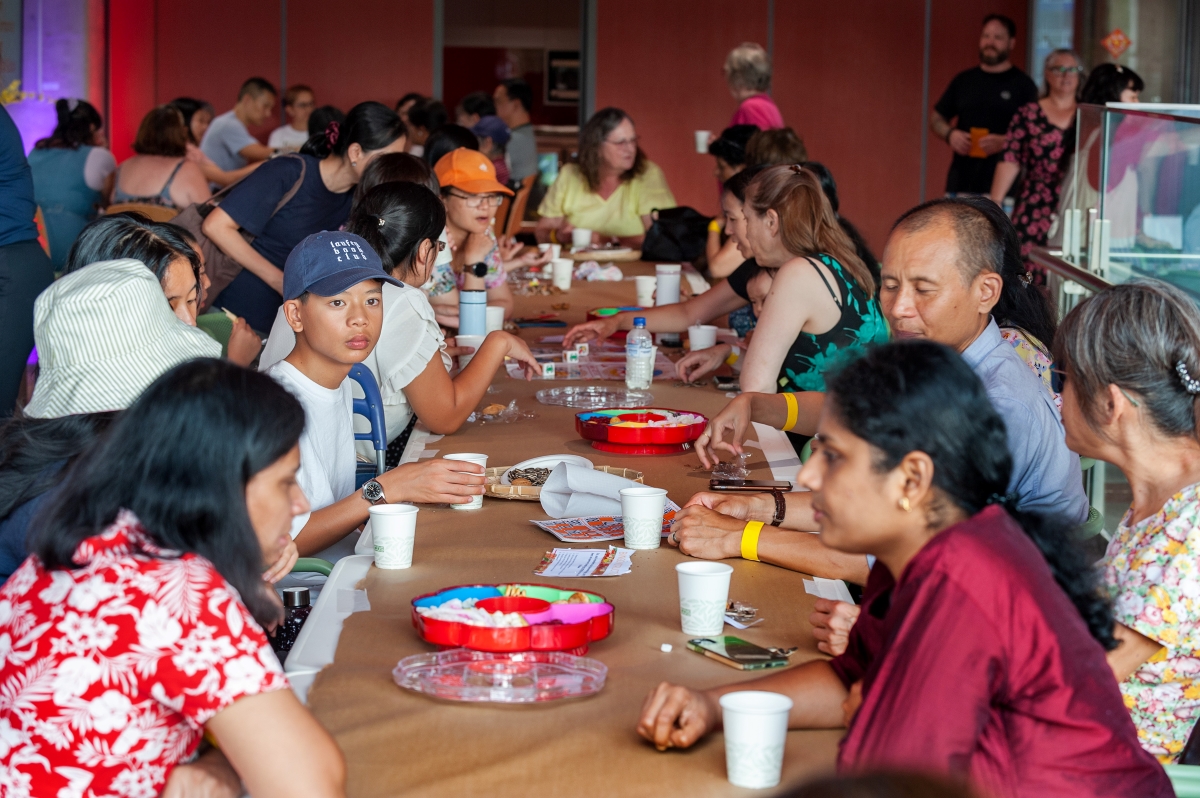 Group of people sitting at a table with food and drinks