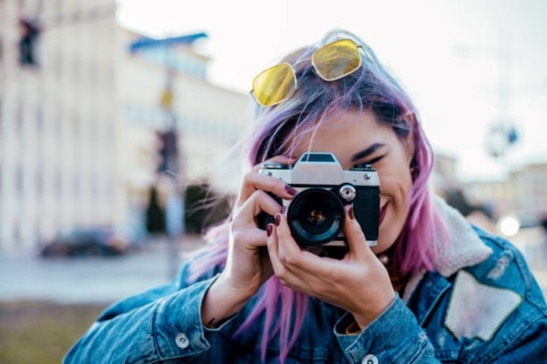 Young Women looking through lens of camera.