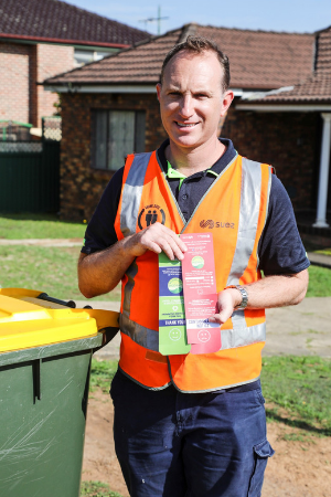 Council recycling inspector holding red and green tags