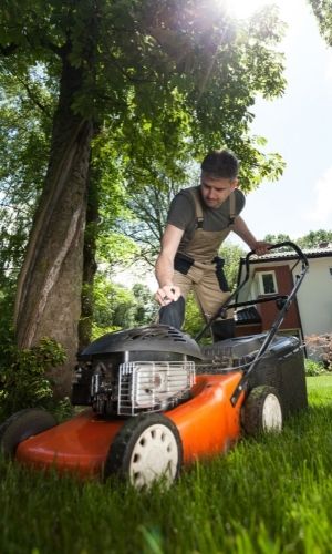 A man using a lawn mower.