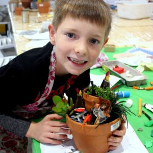 child holding pot plant
