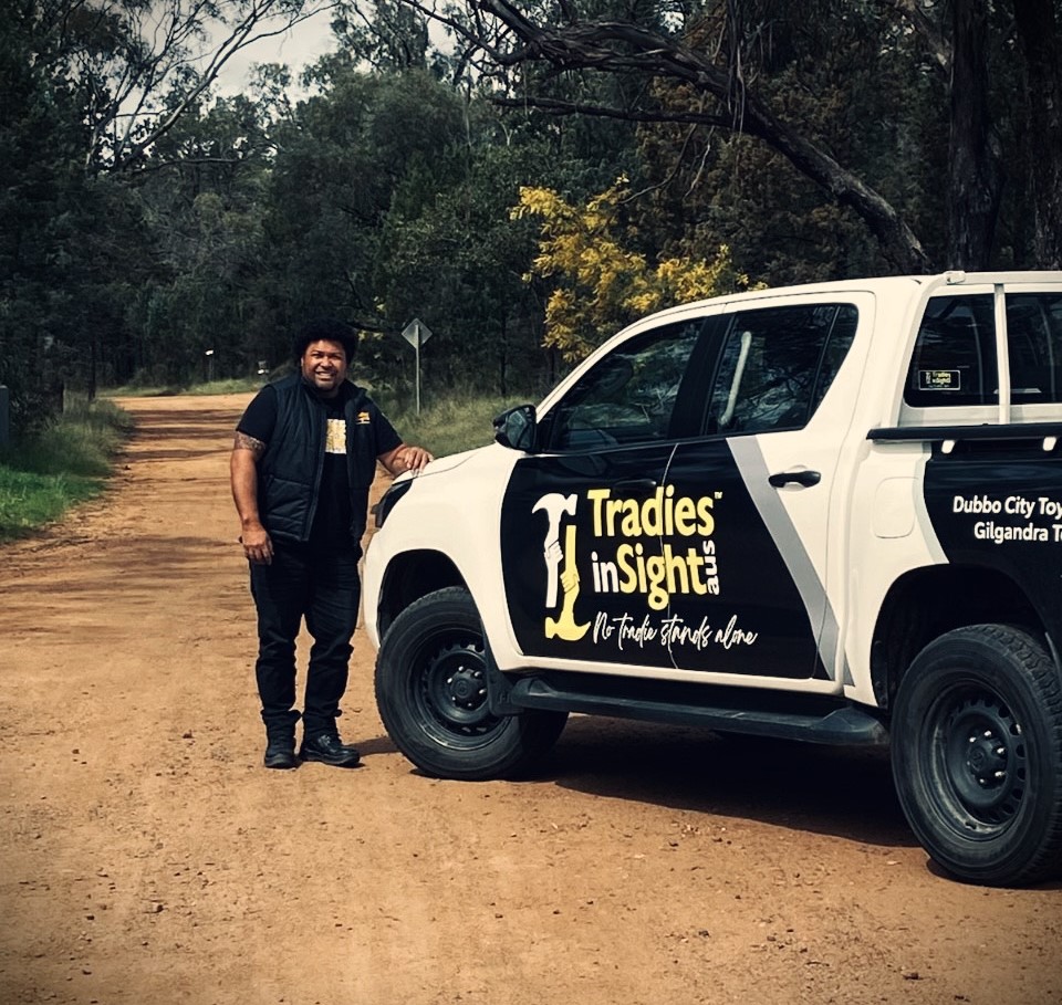 Man smiling standing next to a UTE 