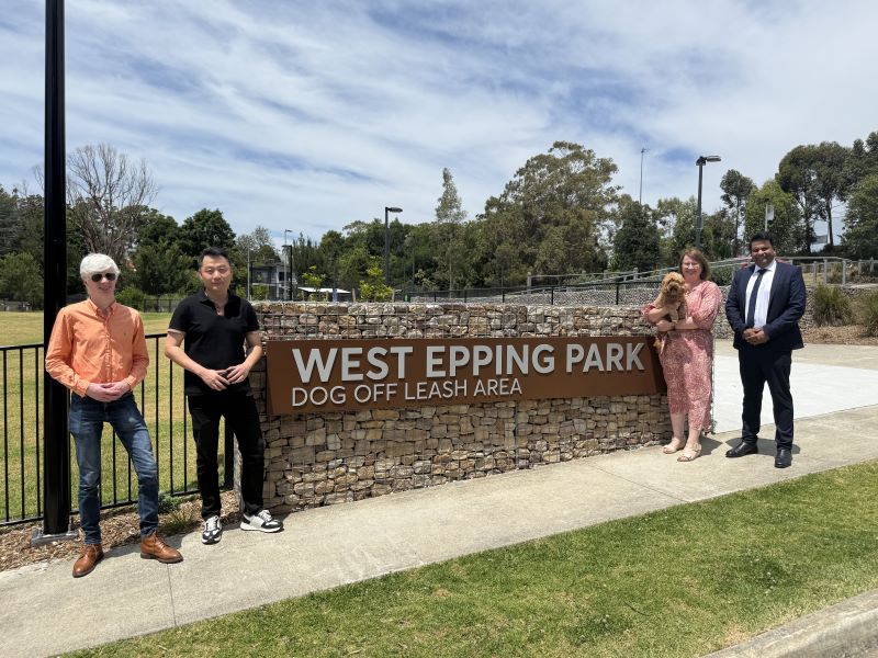 Councillors and MP holding dog in front of park