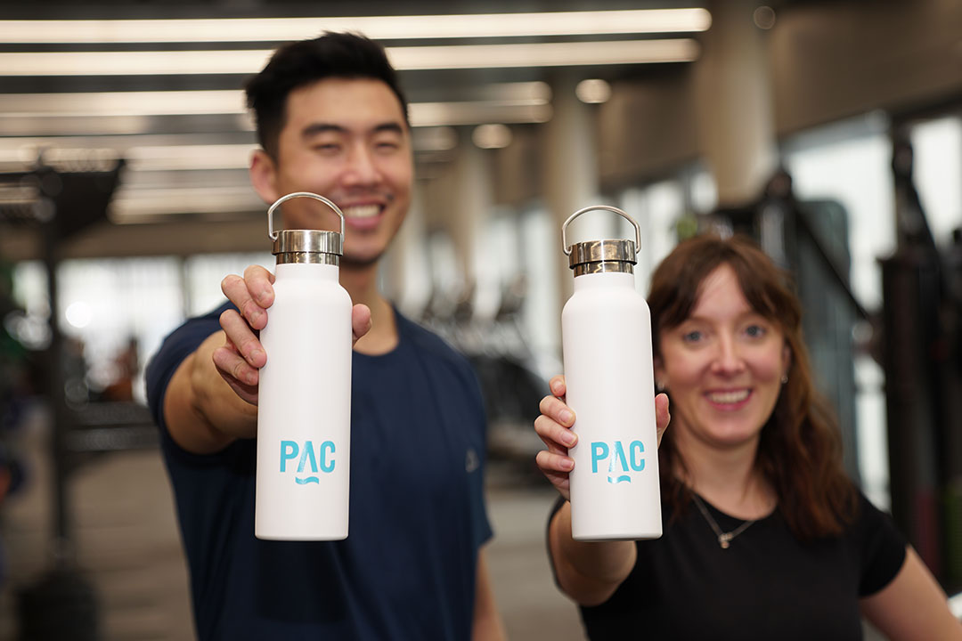 Man and woman holding pac branded bottles