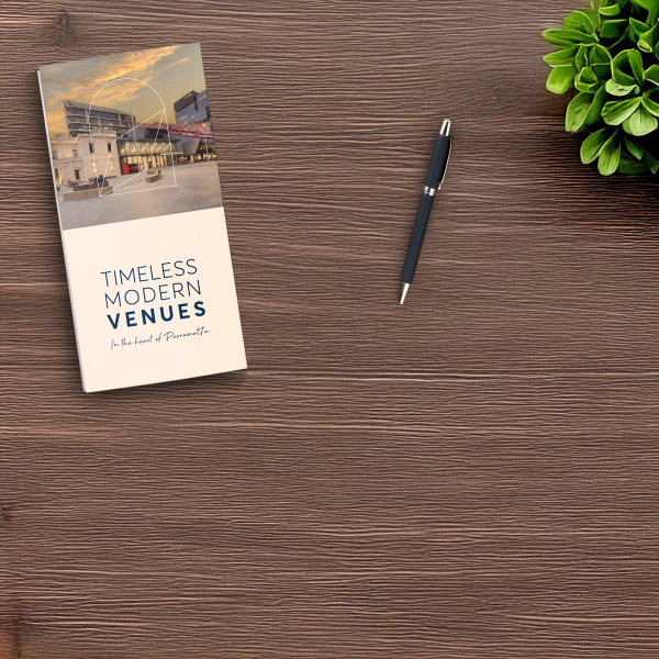 Venues brochure sitting on wooden desk with pen